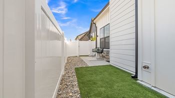 A white fence runs along the side of a house.